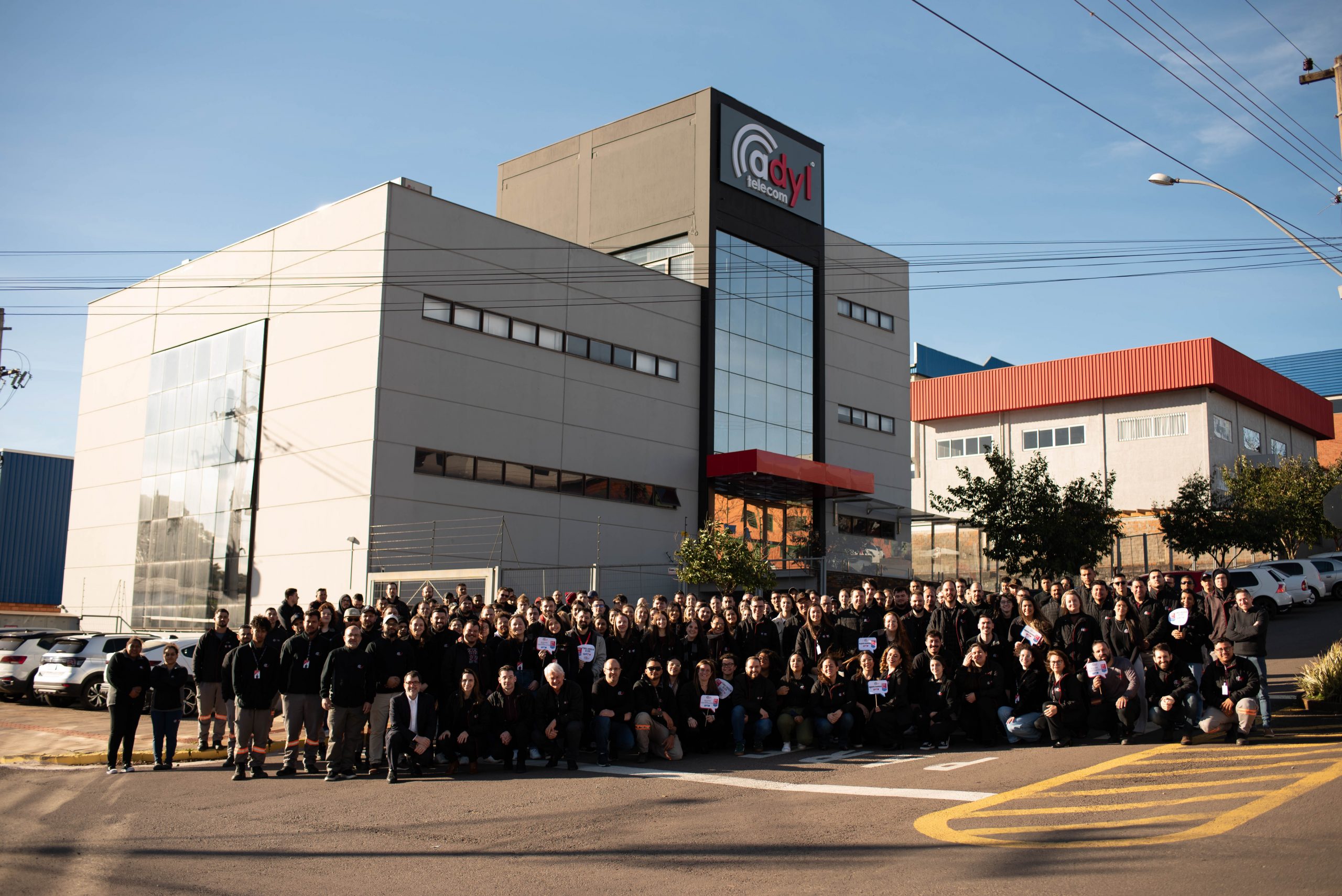 Equipe da Adyl Telecom reunida em frente à sede